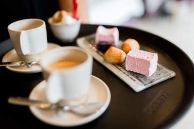 Café gourmand servi au restaurant La Table d’Elka, avec tasses d’espresso, guimauves roses et petites douceurs sucrées.