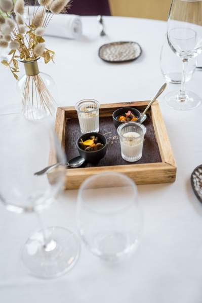 Amuse-bouches servis au restaurant La Table d’Elka, présentés dans un plateau en bois avec verrines et petites cuillères.