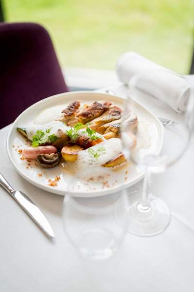 Plat gastronomique servi au restaurant La Table d’Elka, composé de viande, de légumes rôtis et d’une émulsion légère.