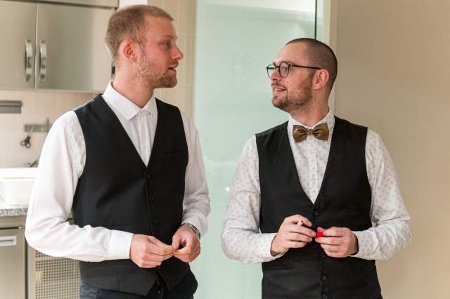 Deux serveurs du restaurant La Table d’Elka en tenue de service noire et blanche, échangeant avant le service en salle.