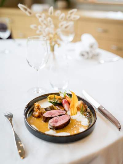 Assiette gastronomique dressée au restaurant La Table d’Elka, composée de viande tranchée, de légumes et d’une sauce onctueuse.