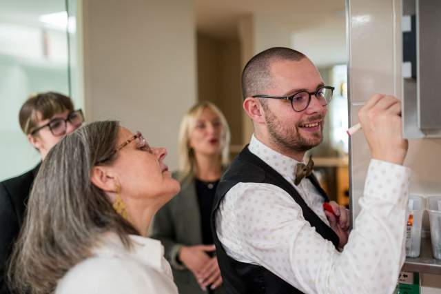 Membres de l’équipe du restaurant La Table d’Elka échangeant autour d’un tableau de service, dans une ambiance de travail conviviale.