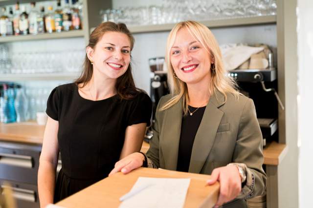 Personnel d’accueil du restaurant La Table d’Elka souriant derrière le comptoir de réception.