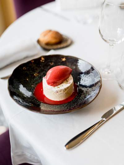 Dessert du restaurant La Table d’Elka, composé d’un entremets à la vanille accompagné d’un sorbet rouge sur coulis de fruits.